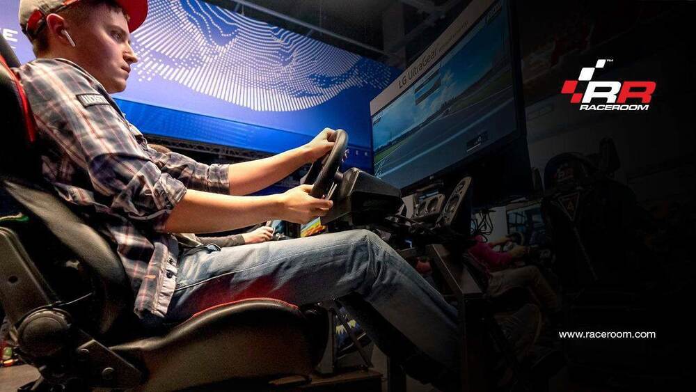 Guest driving a RaceRoom motion simulator